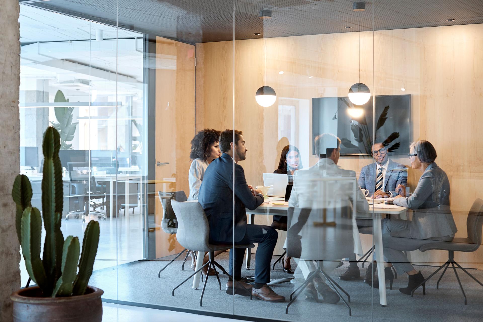 Full length of colleagues discussing in board room